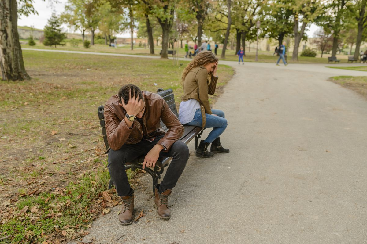 Женщина грустно смотрит в телефон, чувствуя усталость от общения